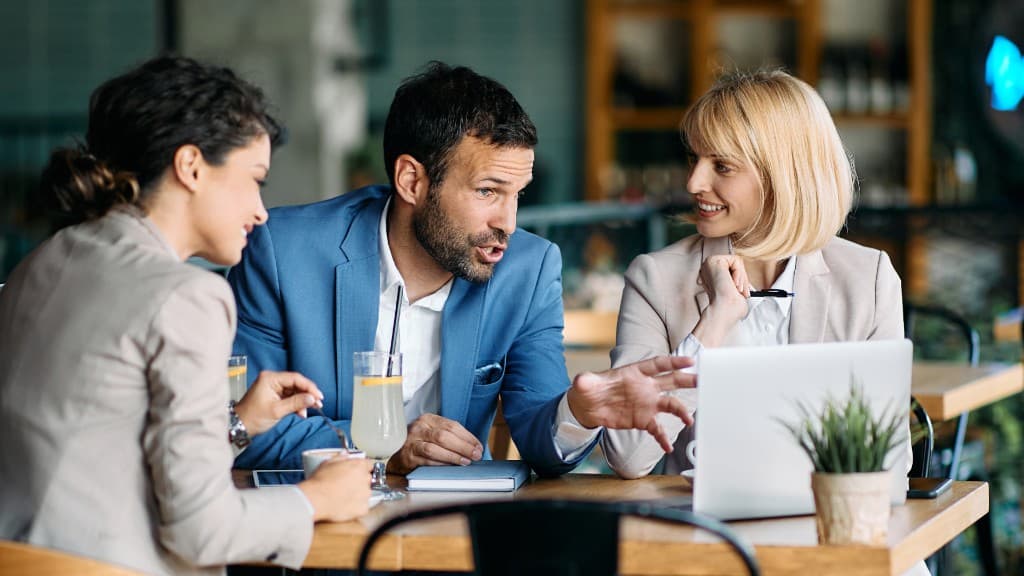 Three colleagues reviewing a payment on a laptop